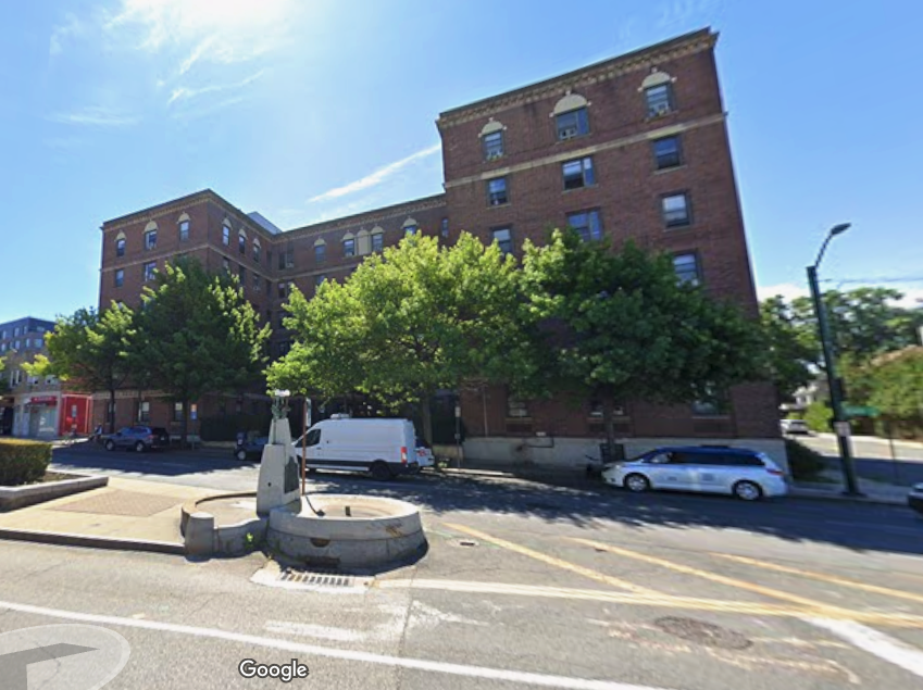 Street scene of a pre-war apartment building on a city street in New Rochelle.